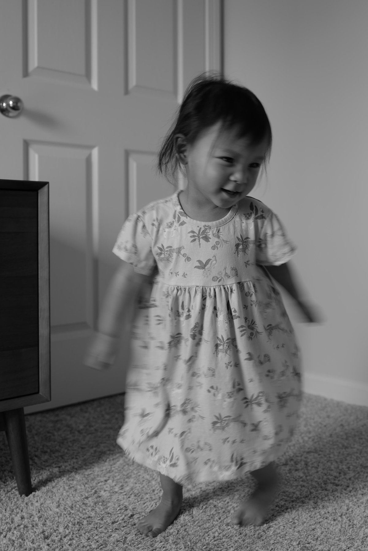 Child dancing by a door, black and white