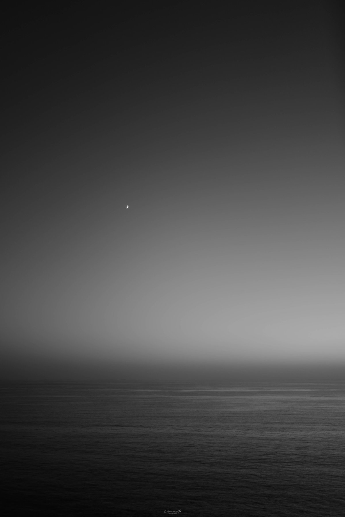 Crescent moon over a calm sea, black and white